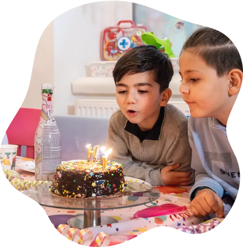 Geburtstagskind bläst die Kerzen der Torte beim Kindergeburtstag in Wien aus